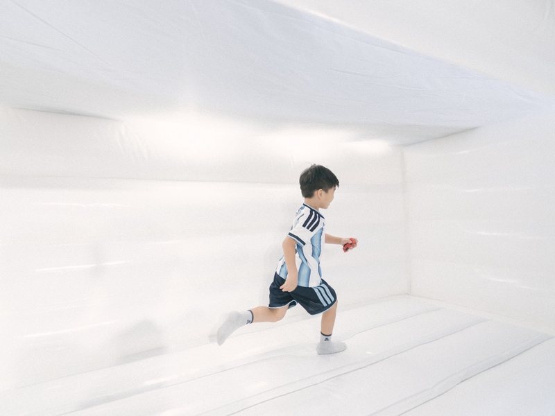 Boy running in a white bouncy castle