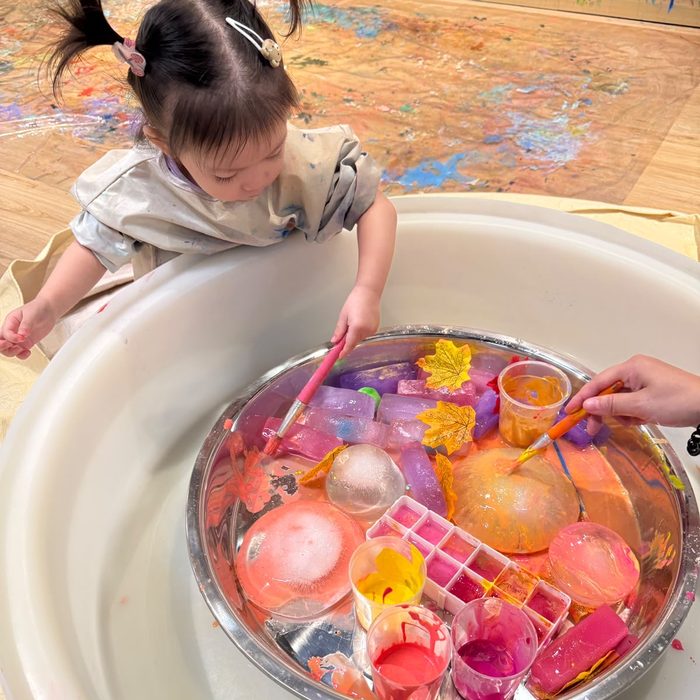 Toddler painting colourful ice shapes