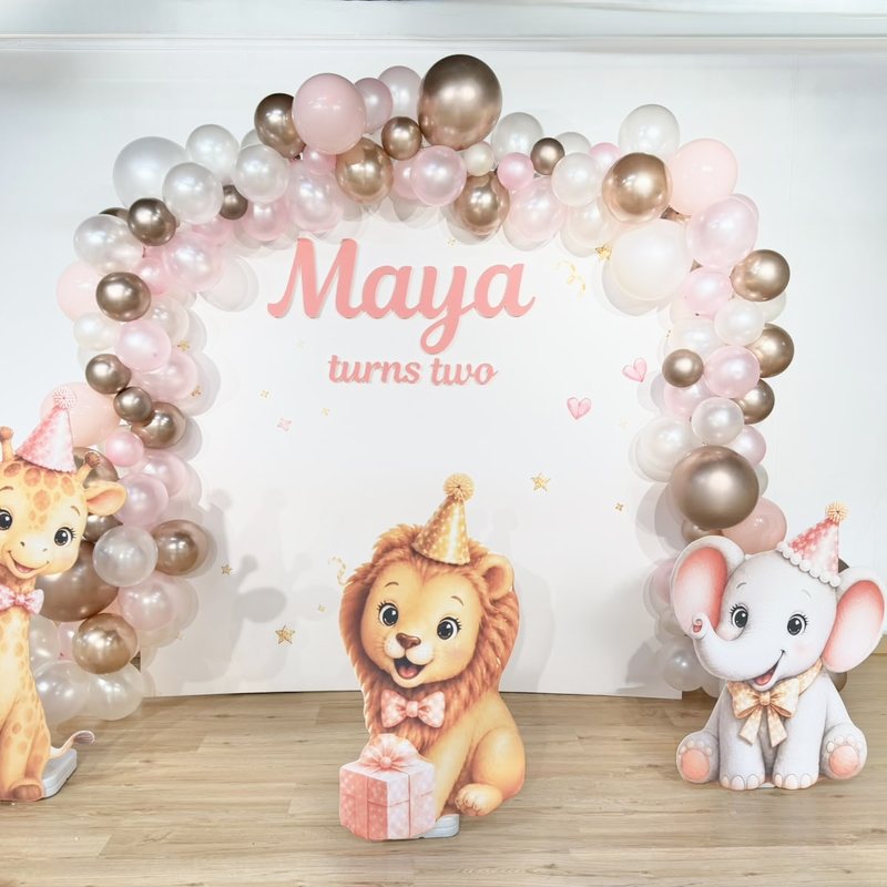 Pink and gold balloon arch with baby giraffe, lion and elephant cut-outs